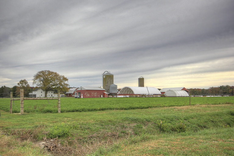 large farm with a red barn and two silos