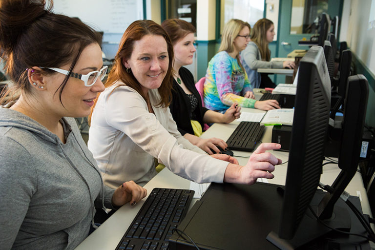 five women working on computers in a classroom