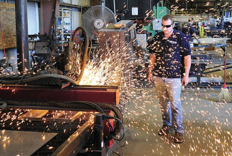 blue collar worker using machinery with sparks